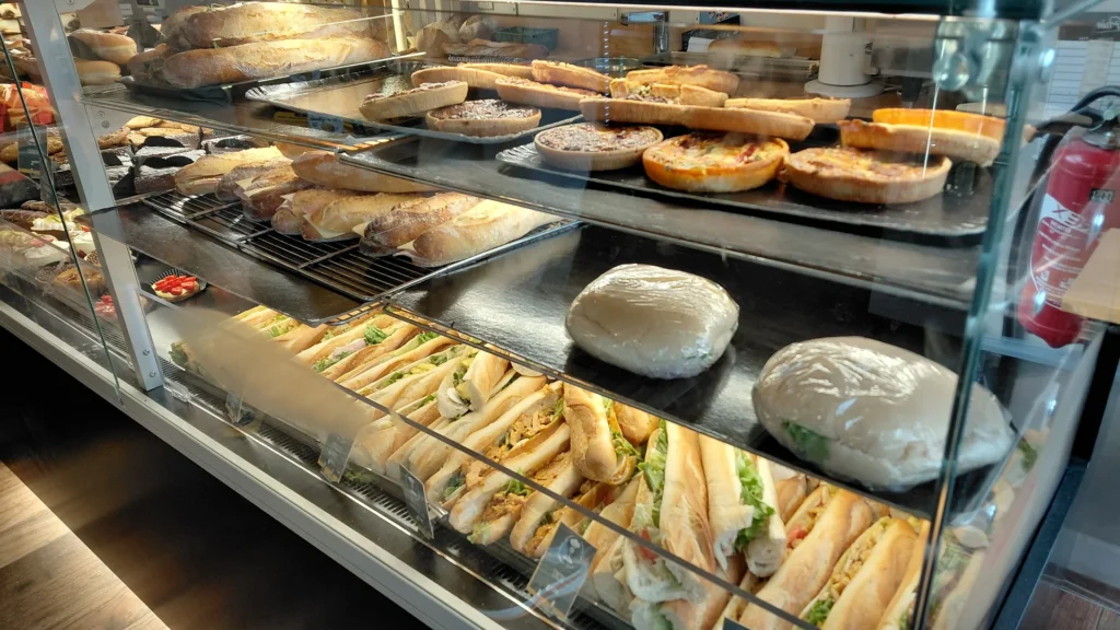 Vitrine réfrigérée de présentation garnie de sandwichs, quiches et pâtisseries
