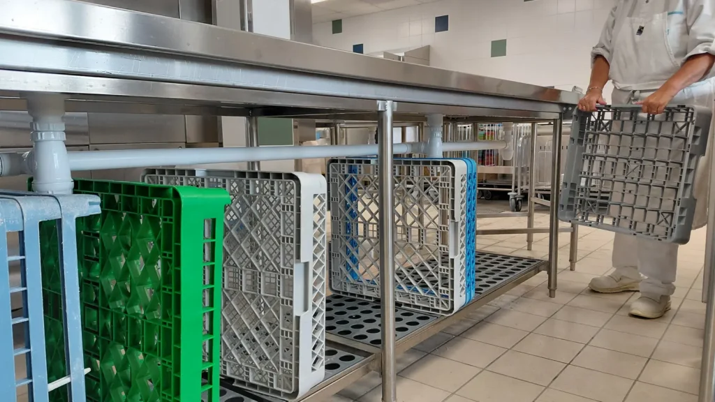 Tables de plonge et casiers de lavage dans une laverie de cuisine collective